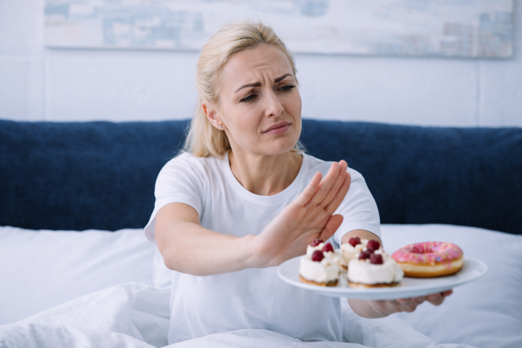 Woman resisting sugary foods, representing mindset strategies to overcome sugar cravings.