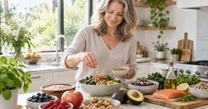Woman over 40 preparing a colorful heart-healthy meal with vegetables, whole grains, avocado, and olive oil.