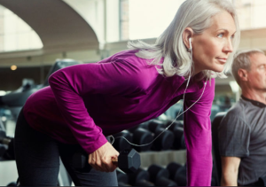 Mature woman lifting weights to build muscle for strength
